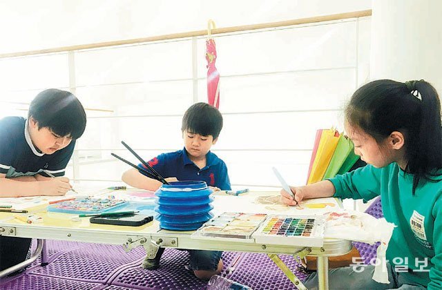 18일 경북 포항시 호미곶 해맞이광장 메인 무대공연장에 마련된 ‘생명의 바다 그림대회’ 행사장에서 참가 학생들이 밑그림 색칠에 집중하고 있다. 장영훈 기자 jang@donga.com