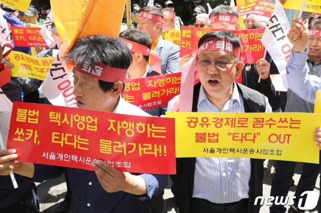 서울개인택시운송사업조합 관계자들이 21일 오전 서울 여의도 더불어민주당 당사 앞에서 집회를 갖고 승합차 공유 서비스 ‘타다’의 퇴출을 요구하고 있다. 2019.5.21/뉴스1 © News1