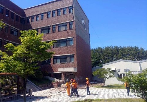 21일 오후 2시 8분께 부산 금정구 부산대 동보미술관 건물 4~5층 벽면의 벽돌이 갑자기 무너져 쏟아져 아래에서 일하고 있던 환경미화원 A 씨(68)가 벽돌 더미에 깔려 숨졌다. 사진=뉴시스(부산경찰청 제공)