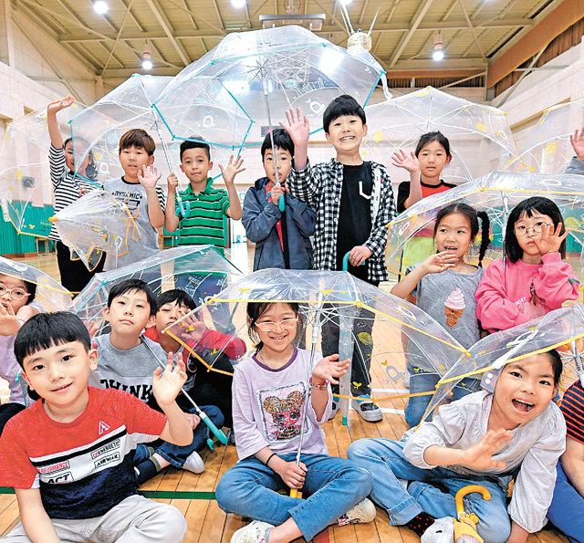 20일 서울 고산초등학교 학생들이 현대모비스가 배포한 투명우산을 들고 있다. 현대모비스는 학교 방문뿐만 아니라 개인 사연 신청 등을 통해 10만 개 이상의 투명우산을 매년 배포하고 있다. 현대모비스 제공