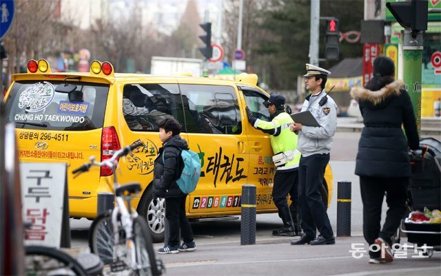 경찰관이 태권도장 통학차량의 안전실태를 점검하고 있다. 동아일보DB