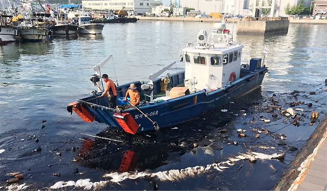 지난해 8월 인천 중구 연안부두 앞바다에서 인천해양경찰서 직원들이 방제정을 타고 흡착포를 이용해 유출된 기름을 걷어내고 있다. 해양경찰청 제공
