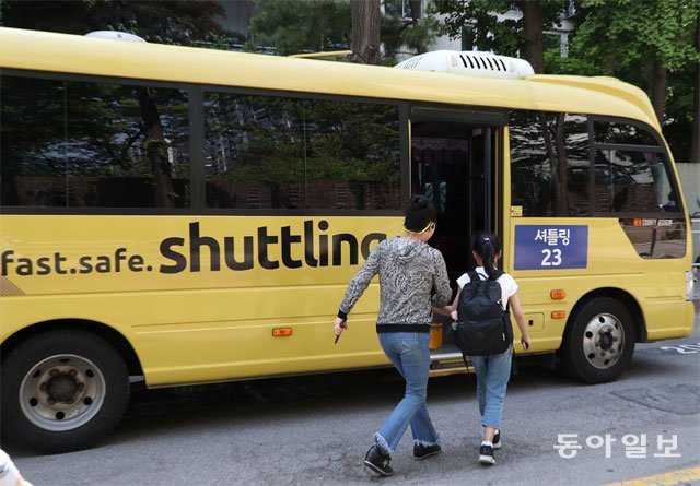 서울 강남구 대치동 학원가에서는 ‘셔틀버스 공유 서비스’가 인기다. 이 서비스를 운영하는 안전도우미(왼쪽)가 학원으로 가야 하는 아이를 셔틀버스에 태우고 있다. 김재명 기자 base@donga.com