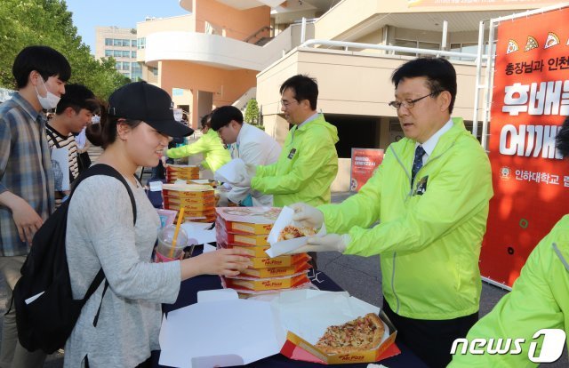 허종식 인천시 정무부시장과 조명우 총장이 학생들에게 피자를 나눠주고 있다. (인하대제공) /  News1