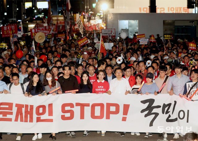 광화문서 6번째 장외집회 자유한국당 황교안 대표(가운데 흰 셔츠)와 나경원 원내대표(황 대표 왼쪽)가 시민들과 함께 
25일 오후 서울 광화문광장에서 ‘문재인 STOP, 국민이 심판합니다’ 6차 장외집회를 마친 뒤 청와대 방향으로 가두행진을 하고 
있다. 김재명 기자 base@donga.com