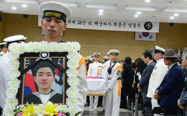 27일 오전 경남 창원시 진해구 해군해양의료원에서 열린 해군 청해부대 ‘최영함’ 장병 고 최종근 하사의 영결식을 마치고 동료 병사들이 최 하사의 영정을 앞세운 채 그의 시신을 운구하고 있다. 창원=뉴스1