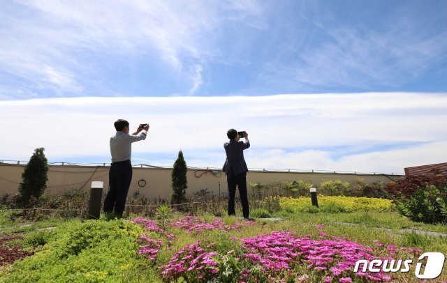 28일 오전 대구 달서구청 옥상 정원에서 시민들이 하늘에 펼쳐진 이색적인 구름을 관찰하고 있다. © News1