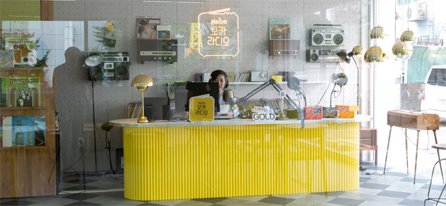 28일 서울 마포구 합정동에 마련된 동서식품의 다섯 번째 팝업 카페 ‘모카라디오’의 라디오 부스에서 DJ가 시민들이 적은 사연과 신청곡을 소개하고 있다. 동서식품 제공