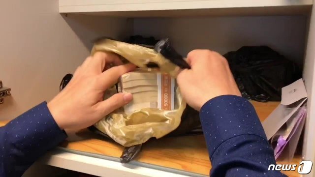조사관이 고액체납자의 주방 싱크대에서 돈다발을 발견하고 있다.(국세청 자료)© 뉴스1