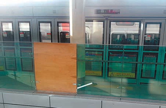 서울 지하철 1호선 노량진역 환승계단 옆 깨진 유리를 나무판으로 막아 놓았다.