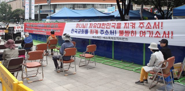 서울광장을 둘러친 경찰 바리케이드 뒤에 한 기독교 단체가 집회를 준비하고 있다.