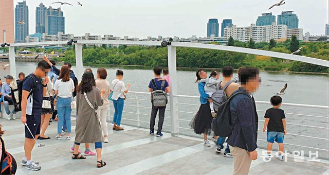 1일 서울 여의도선착장을 출발한 한 유람선 갑판 위로 나와 있는 승객들. 유람선이 운항하는 동안 갑판 위에는 수용 정원 80명을 초과한 승객들이 몰려 있기도 했다. 박상준 기자 speakup@donga.com