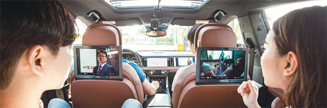 4일 제주 제주시 제주테크노파크에서 운행 중인 차세대 방송솔루션 ‘5G-ATSC 3.0’ 시연 차량에서 SK텔레콤 모델들이 좌석 앞 스크린을 통해 서로 다른 TV 광고를 시청하고 있다. SK텔레콤 제공
