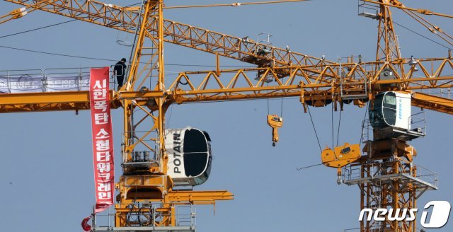 한국노동조합총연맹과 전국민주노동조합총연맹 소속 전국 타워크레인 노동자들이 파업에 들어간 4일 세종시의 한 건설현장에서 ‘시한폭탄 소형타워크레인 즉각폐기’란 문구가 적힌 타워크레인에 노동자가 올라가 있다. © News1