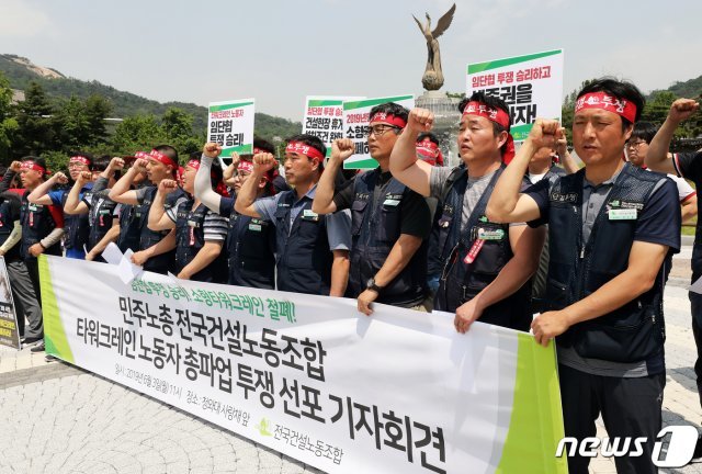 지난 3일 서울 종로구 청와대 사랑채 앞에서 열린 민주노총 건설노조 타워크레인 노동자 총파업 투쟁 선포 기자회견에서 참가자들이 총파업 구호를 외치고 있다. © News1