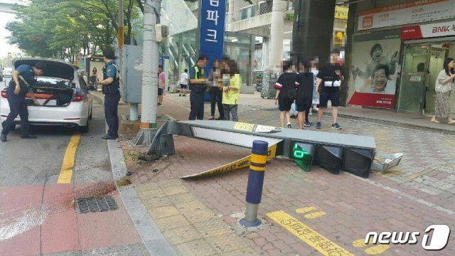 5일 오전 7시40분쯤 부산 해운대구 재송동의 한 아파트 앞에서 택시 한 대가 보행 신호등을 충격하고 상가로 돌진했다. 보행 신호등이 바닥에 쓰러진 모습.(부산지방경찰청 제공)© 뉴스1
