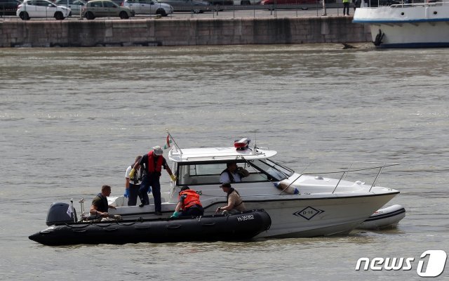 4일 오후 (현지시간) 헝가리 부다페스트 다뉴브강 머르기트 다리 인근 유람선 ‘허블레아니호’ 침몰 현장에서 정부합동신속대응팀과 헝가리 수색팀이 수습한 시신을 다른 보트에 옮기고 있다. 2019.6.4/뉴스1 © News1