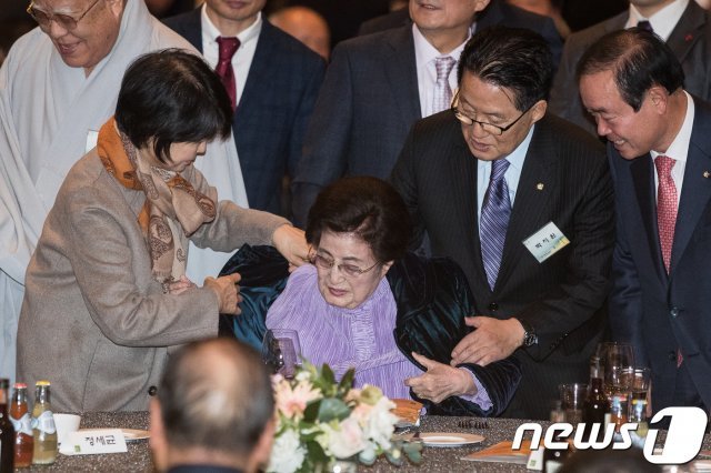 박지원 전 국민의당 대표가 7일 서울 여의도 63컨벤션센터에서 열린 김대중 전 대통령 노벨평화상 수상 17주년 기념식에서 이희호 여사의 외투를 받아들고 있다. 2017.12.7/뉴스1 © News1