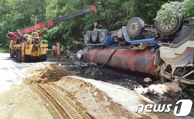 11일 오전 9시 45분쯤 경북 구미시 옥성면 대원리 지방도로에서 폐유를 운반하던 27톤 유조차가 전복돼 폐유가 유출되는 사고가 발생하자 환경당국이 긴급 방제작업을 벌인 뒤 크레인을 동원해 전복 차량을 바로 세우는 작업을 하고 있다. (구미시제공)2019.6.11/뉴스1 © News1