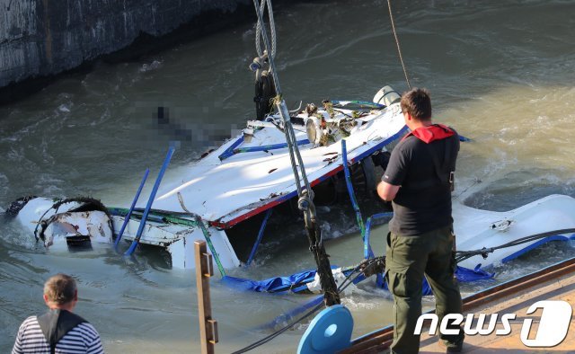 (부다페스트(헝가리)=뉴스1)  유람선 ‘’허블레아니호‘’ 사고 2주째인 11일 오전(현지시간) 헝가리 부다페스트 다뉴브강 머르기트 다리 인근 침몰현장에서 정부합동신속대응팀과 헝가리 대테러청(TEK) 등 관계자들이 선체인양작업을 하고 있다. 선체 일부가 수면위로 모습을 드러내고 있다. 2019.6.11/뉴스1