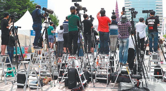 지난달 25일 서울 청계광장에서 열린 청소년 축제에서 아이돌 그룹을 찍기 위해 카메라에 망원렌즈를 장착한 채 사다리 위에 올라간 사람들. 김재명 기자 base@donga.com