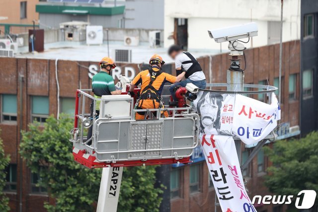 12일 오전 7시 50분쯤 40대 남성 김모씨가 대구 남구 봉덕동 영대병원네거리에 있는 약 10m 높이의 CCTV 타워에 올라가 시위를 벌였다. 현장에 출동한 경찰과 소방 관계자들이 4시간 가까운 설득 끝에 11시 55분쯤 굴절차를 이용해 타워에 접근해 남성을 태우고 있다. 경찰은 남성을 상대로 자세한 경위를 조사할 예정이다. © News1