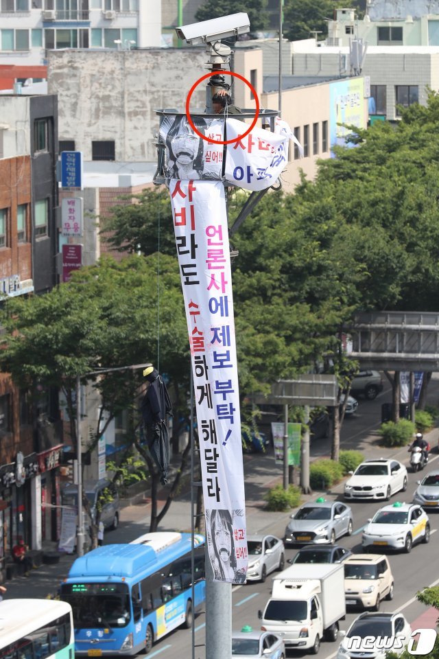 12일 오전 7시50분쯤 신원을 알 수 없는 한 남성이 대구 남구 봉덕동 영대병원네거리 약 10m 높이의 CCTV 타워에 올라가 시위를 벌이고 있다. 현장에 출동한 경찰과 소방 당국은 남성을 설득하는 한편 만일의 사태에 대비하기 위해 타워 주변에 에어매트 등 안전장치를 설치해 놓고 있다. © News1