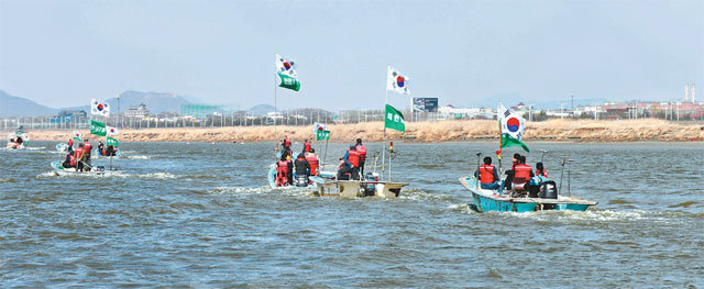 경기 김포시가 올 4월 1일 한강 하구에서 개최한 물길 열기 행사에서 작은 배들이 물길을 열어가고 있다. 김포시 제공