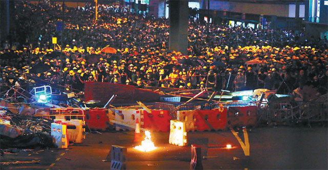 홍콩 反中시위 부상자 속출… 관공서 폐쇄 12일(현지 시간) 밤 홍콩에서 ‘범죄인 인도 법안’ 반대 
시위대가 도로에 바리케이드를 치고 입법회 건물을 둘러싸고 있다. 바리케이드 앞에는 시위대가 던진 가솔린 폭탄이 불타고 있다. 이날
 당국이 최루탄과 고무탄 등으로 시위대를 진압해 약 70명이 다치고 2명은 중상을 입은 것으로 알려졌다. 13일부터 주말까지 홍콩
 주요 관공서가 문을 닫는 가운데 수백 명의 시위대가 입법회 건물 인근에 남아 언제 강행될지 모를 법안 표결을 저지하기 위해 
대기하고 있다. 홍콩=AP 뉴시스