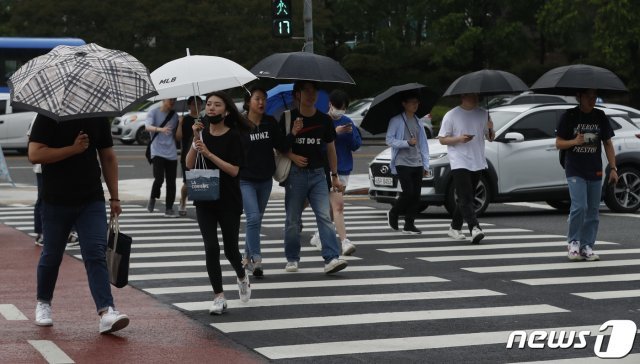 비가 내린 18일 오후 대전 유성구 충남대학교 앞 횡단보도에서 우산을 쓴 시민들이 발걸음을 재촉하고 있다. 2019.6.18/뉴스1 © News1