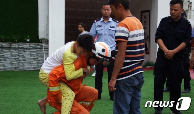 한 소방대원이 아이를 업어 안전한 곳에 내려놓고 있다 - 웨이보 갈무리