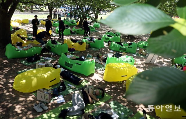 참가자들이 시원한 나무그늘 아래에서 낮잠을 자고 있다.
