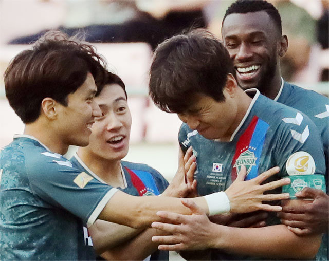프로축구 전북 이동국(오른쪽에서 두 번째)이 23일 수원과의 안방경기에서 전반 1분 만에 ‘안면슛’을 넣은 후 얼굴을 찌푸리며 동료들의 축하를 받고 있다. 전주=뉴스1