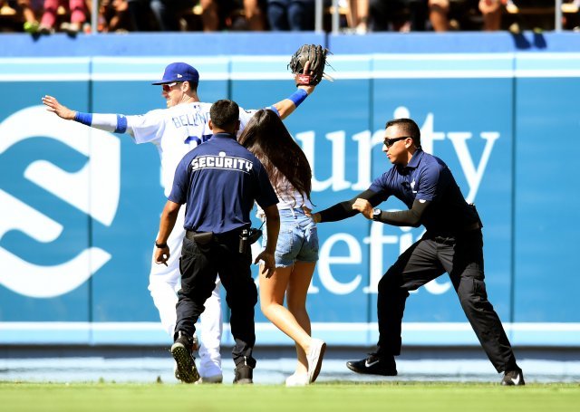 24일 캘리포니아주 로스앤젤레스 다저스타디움에서 열린 콜로라도 로키스와 경기에서 한 여성팬이 난입해 코디 벨린저에게 포옹을 시도하는 모습. 사진=ⓒGettyimages/이매진스