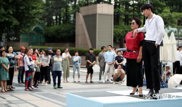 점심시간을 이용해 직장인들과 시민들이 패션쇼를 구경하고 있다.