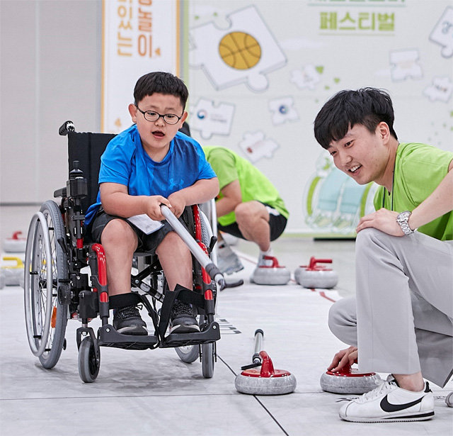 행복얼라이언스가 16일 인천 송도에서 개최한 ‘세잎클로버 플러스 페스티벌’에서 휠체어 사용 아동이 컬링을 체험하고 있다. 행복얼라이언스 제공