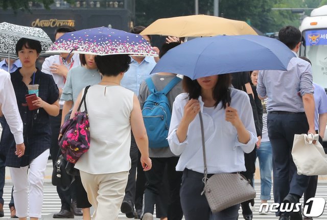 본격적인 장마가 시작된 26일 오후 서울 광화문네거리에서 우산을 쓴 시민들이 발걸음을 옮기고 있다. 2019.6.26/뉴스1 © News1