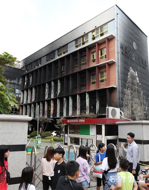 27일 서울 은평구 은명초등학교 학생들이 전날 발생한 화재로 외벽에 검은 그을음이 남은 별관 건물을 쳐다보고 있다. 이 학교는 이날부터 이틀간 휴교에 들어갔다. 김재명 기자 base@donga.com
