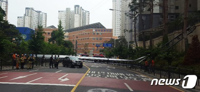 28일 오전 8시 50분쯤 김포시 운양동의 한 아파트에서 이삿짐을 옮기던 사다리 차량이 쓰러져 도로를 달리던 차량을 덮쳤다. 소방대원들이 사고를 수습하고 있다.(김포소방서제공)