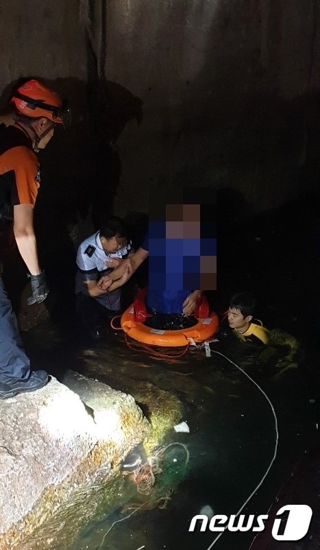 군산해경 비응파출소 직원들이 바다로 추락한 차량 운전자를 구조해 육지로 끌어 올리고 있다. © 뉴스1