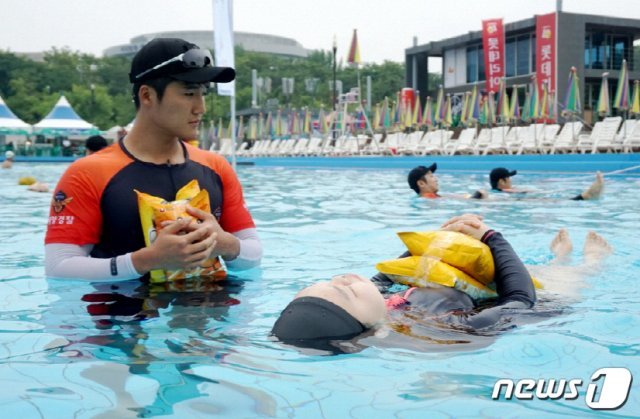 인천해경 대원들이 29일 서울시 여의도 야외수영장에서 청소년들에게 생존수영 교육을 하고 있다.(인천해경제공)