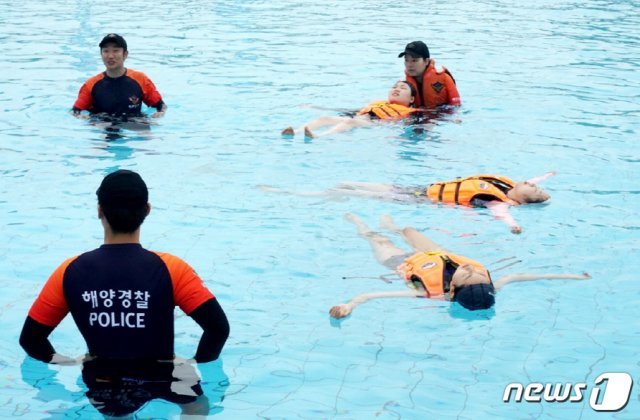 인천해경 대원들이 29일 서울시 여의도 야외수영장에서 청소년들에게 생존수영 교육을 하고 있다.(인천해경제공)