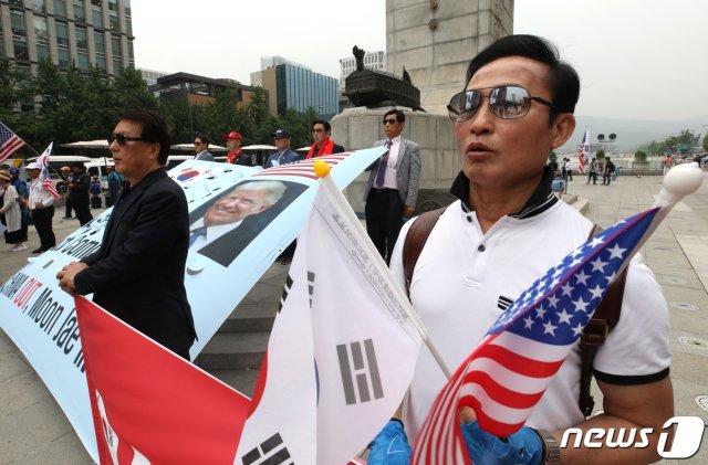 28일 오전 서울 종로구 광화문광장에서 보수단체 회원들이 도널드 트럼프 미국 대통령 방한 환영 및 한미 동맹 강화 촉구 기자회견을 열고 애국가을 부르고 있다. 2019.6.28/뉴스1 © News1