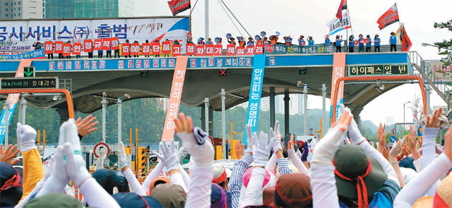 30일 경기 성남시 경부고속도로 서울요금소에서 민노총 등에 소속된 한국도로공사 요금수납원들이 공사의 직접고용을 요구하며 고공 농성을 벌이고 있다. 아래에서는 이에 동조하는 조합원들이 격려의 박수를 치고 있다. 이들은 자회사를 통한 정규직 전환에 반대하며 집회를 벌였다. 성남=뉴스1