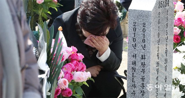 올 3월 22일 제3회 서해수호의 날을 맞아 국립대전현충원을 찾은 천안함 46용사 유족이 묘역 앞에서 슬픔에 잠겨 있다.동아일보DB