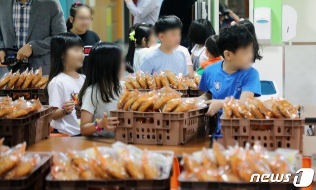 학교 비정규직 노동자들이 총파업에 들어간 3일 세종시의 한 초등학교에서 학생들이 대체 급식으로 준비된 빵과 음료를 가져가고 있다. 2019.7.3./뉴스1 © News1