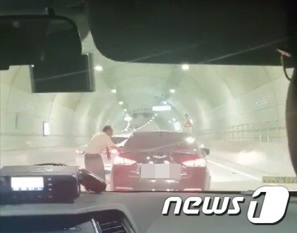 3일 오후 5시45분쯤 부산 서구 암남동의 천마산 터널에서 술에 취해 주행하던 제네시스 운전자 A씨(44)가 복귀하던 소방대원에게 덜미를 잡혔다. 소방대원이 운전석 문을 붙잡은 채 112에 신고하는 모습.(부산소방재난본부 제공)© 뉴스1