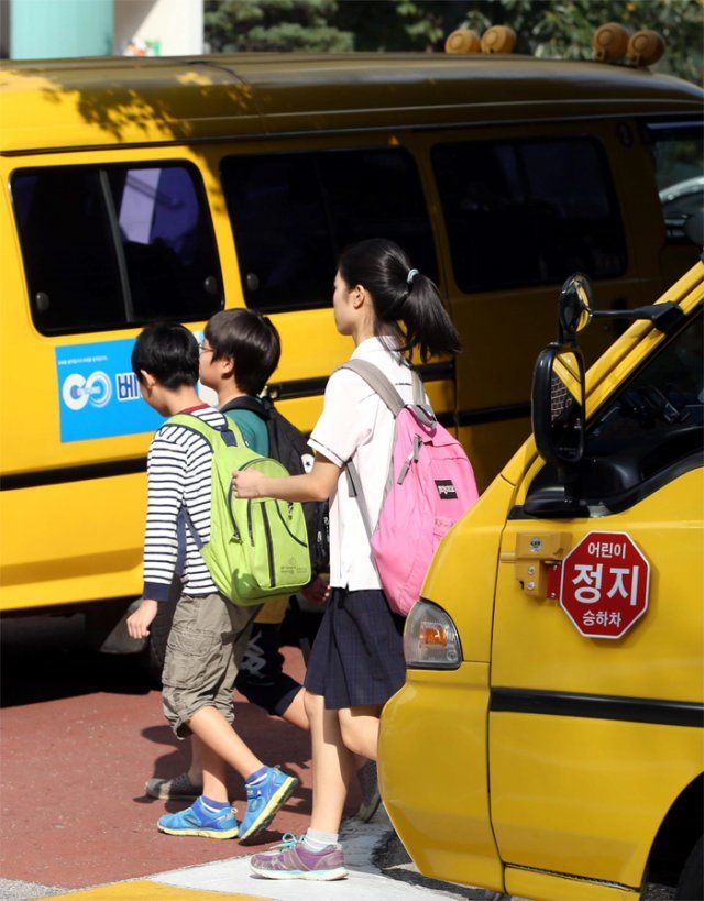 서울 노원구의 한 어린이 보호구역(스쿨존)에서 정차된 어린이 통학차량 사이로 어린이들이 길을 걷고 있다. 동아일보DB