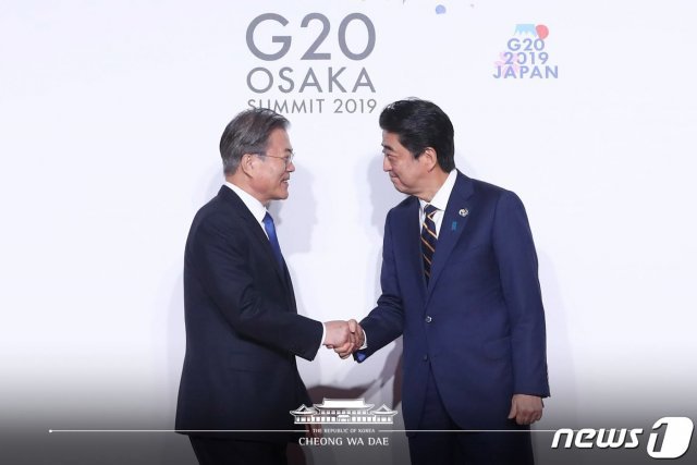 문재인 대통령이 지난 6월28일 오전 인텍스 오사카에서 열린 G20 정상회의 공식환영식에서 의장국인 일본 아베 신조 총리와 악수하고 있다. (청와대 페이스북) 2019.6.28/뉴스1