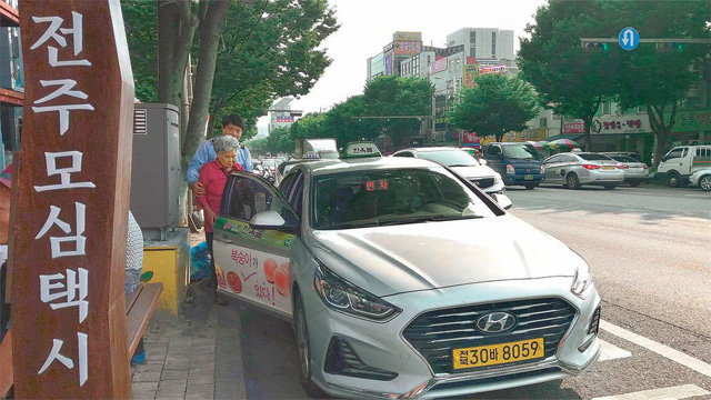 전북 전주시가 2017년부터 교통오지 마을 주민들을 위해 운행 중인 공공형 택시 ‘모심택시’에 한 할머니가 운전기사의 도움을 받아 타고 있다. 전주시 제공